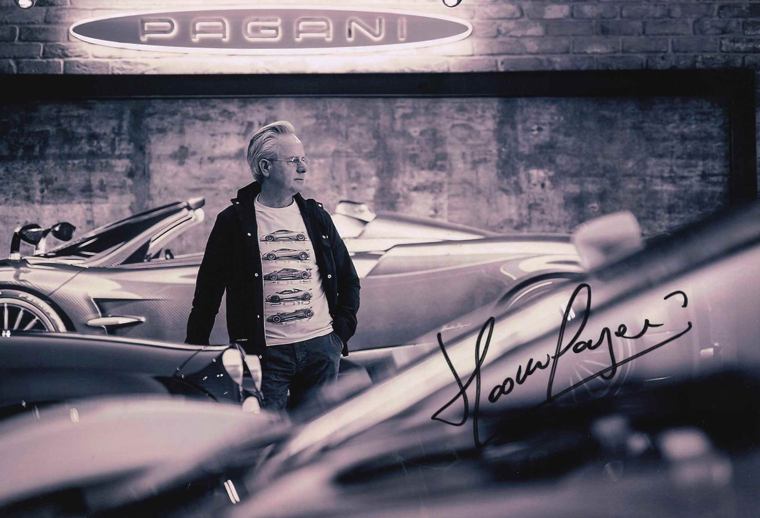 Fotografia autografata Horacio Pagani nell'atelier Pagani Automobili – bianco e nero tra le hypercar – autografo originale pennarello nero – condizioni Excellent