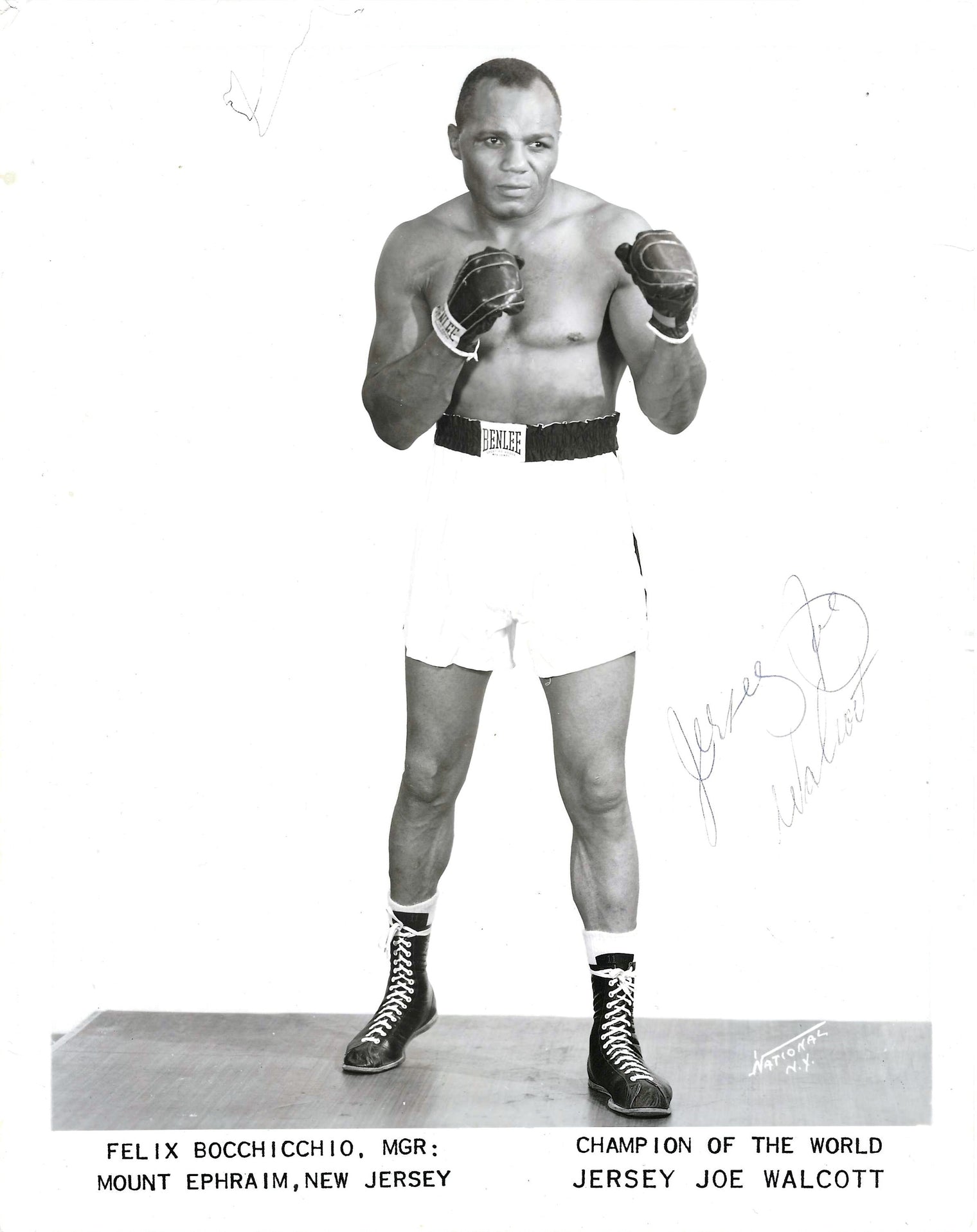 Press photo autografata Jersey Joe Walcott posa da combattimento guantoni Benlee pantaloncini bianchi studio National New York anni 50 bianco e nero – autografo originale penna grigio-blu sul lato destro – 26x20,4 cm – condizioni Excellent