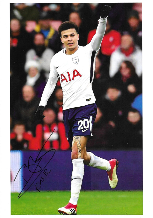 Fotografia autografata Dele Alli esultanza a figura intera braccio alzato maglia Tottenham Home Nike bianca sponsor AIA numero 20 pantaloncini blu guanti neri scarpini Adidas rossi – autografo originale pennarello nero in basso a sinistra – 29,7x21 cm – condizioni Excellent