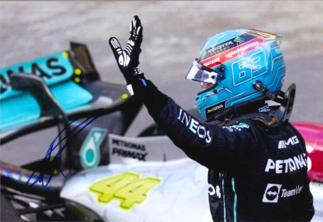 Fotografia autografata George Russell Mercedes-AMG Petronas F1 saluto a bordo pista casco azzurro numero 63 Monster Energy tuta nera INEOS Petronas IWC – autografo originale pennarello blu – 29x20 cm