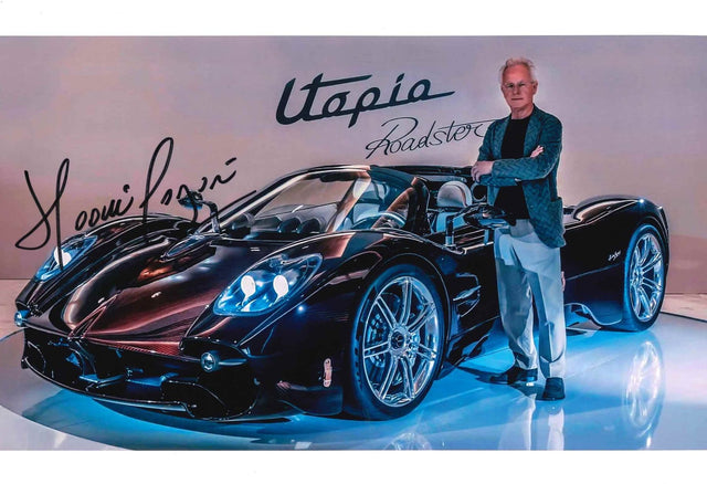 Fotografia autografata Horacio Pagani fondatore Pagani Automobili accanto Utopia Roadster hypercar V12 carbonio nera presentazione Modena scritta stilizzata Utopia Roadster sfondo – autografo originale pennarello nero – 30x20 cm