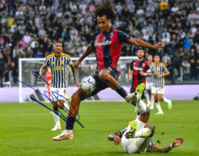 Fotografia autografata Joshua Zirkzee Bologna Home 2023/24 maglia Macron strisce rossoblù sponsor Saputo stacco aereo in azione contro la Juventus allo Stadium – autografo pennarello blu – 25x20 cm