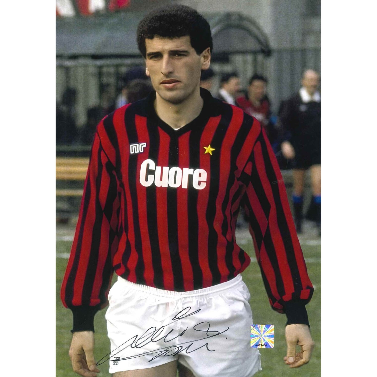 Fotografia autografata Mauro Tassotti Milan Home 1983/84 maglia Ennerre rossonera strisce verticali sponsor Olio Cuore stella dorata pantaloncini bianchi posa pre-partita bollino Witnessed AA21484 – autografo pennarello nero – 29,6x20,9 cm