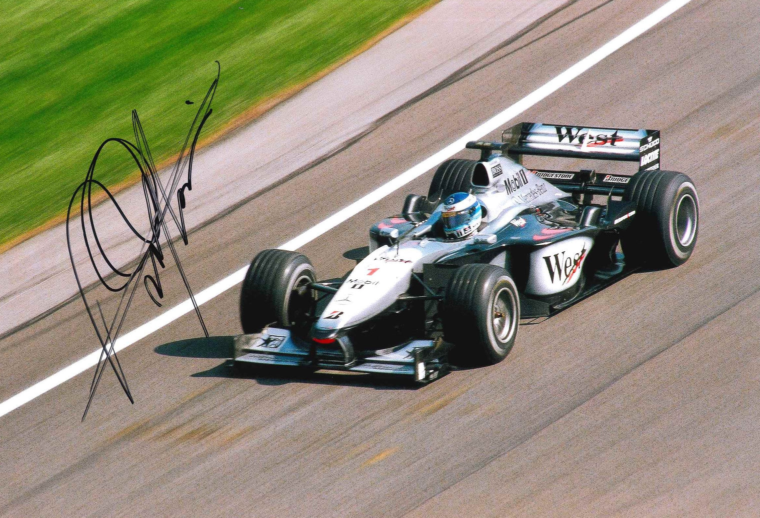 Fotografia autografata Mika Häkkinen – McLaren MP4-15 F1 stagione 2000 numero 1 campione del mondo in carica – livrea West Mercedes-Benz – autografo originale pennarello nero – formato 30x20 cm – COA incluso