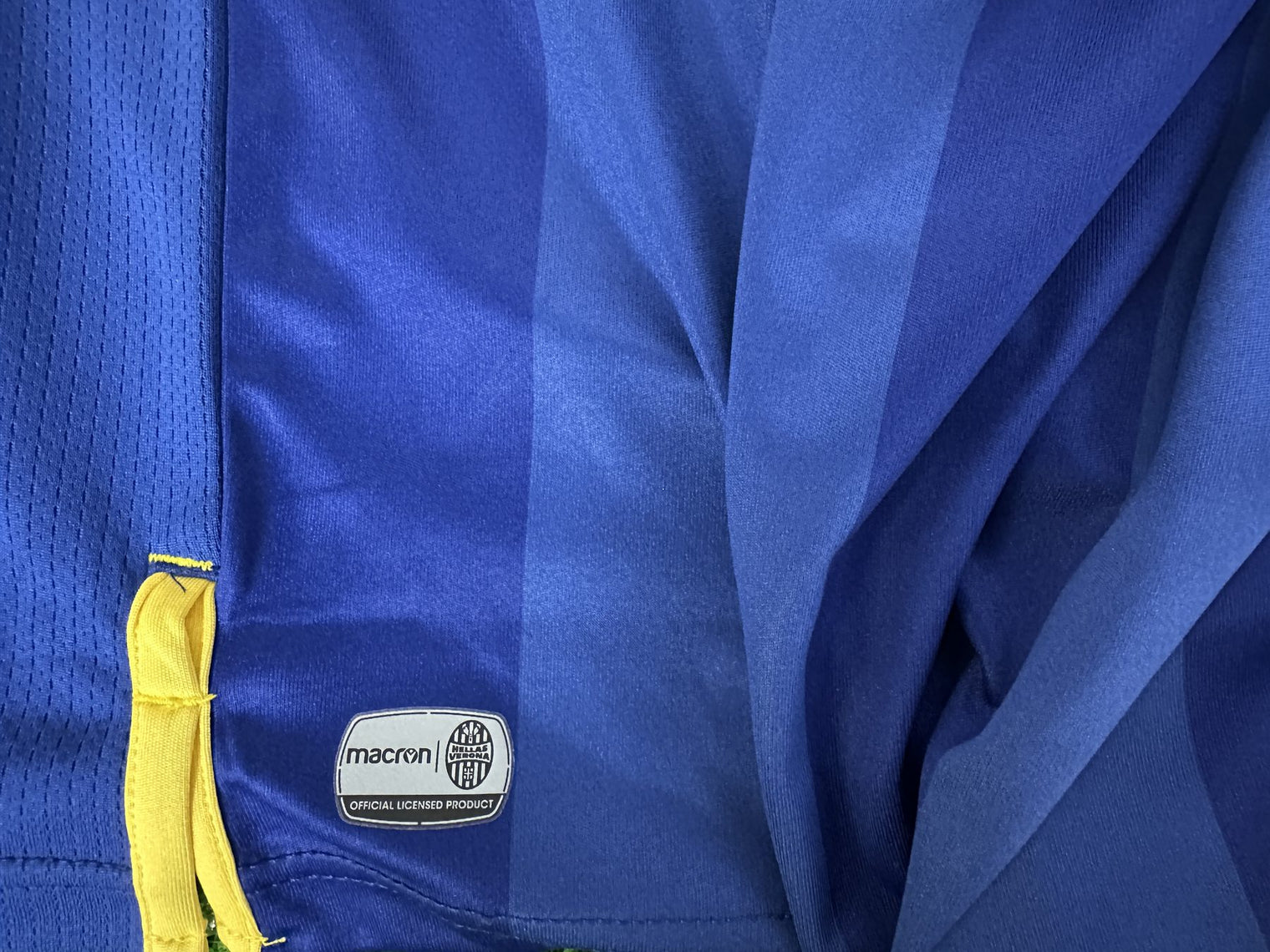Dettaglio laterale maglia Hellas Verona Home 2020-21 – logo Macron e fascia gialla