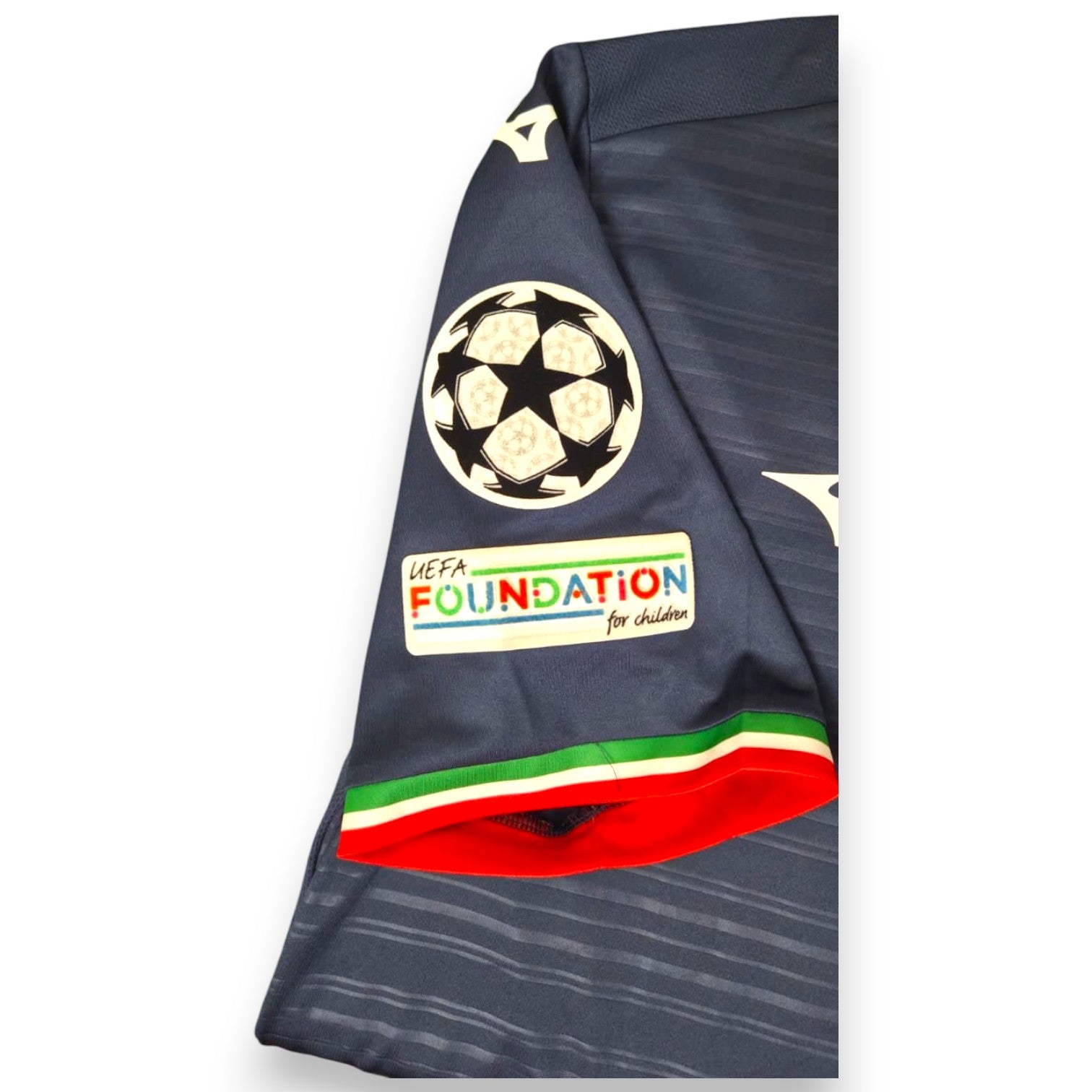 Dettaglio manica maglia Lazio Away 2023-24 – patch UEFA Champions League e UEFA Foundation – bordo tricolore