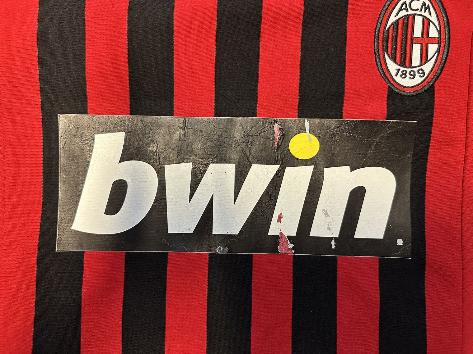 Dettaglio sponsor frontale bwin maglia Milan 2007-08 – screpolature e distacchi della stampa dovuti al tempo