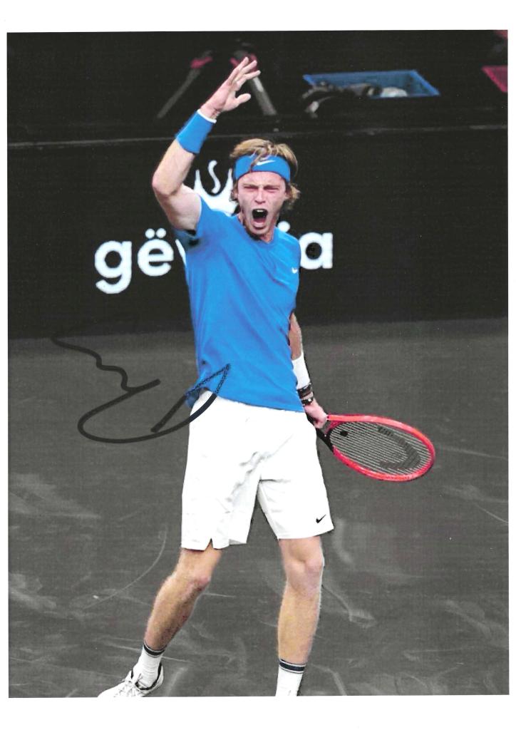 Fotografia autografata Andrey Rublev in esultanza – tuta Nike blu racchetta Head rossa – autografo originale pennarello nero ATP Finals Torino 2024 – 21x29,7 cm – condizioni Excellent