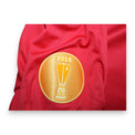 Dettaglio patch UEFA Europa League Winner 2015 maglia Siviglia 2015-16 – coppa dorata su sfondo oro – detentori titolo stagione 2015-16