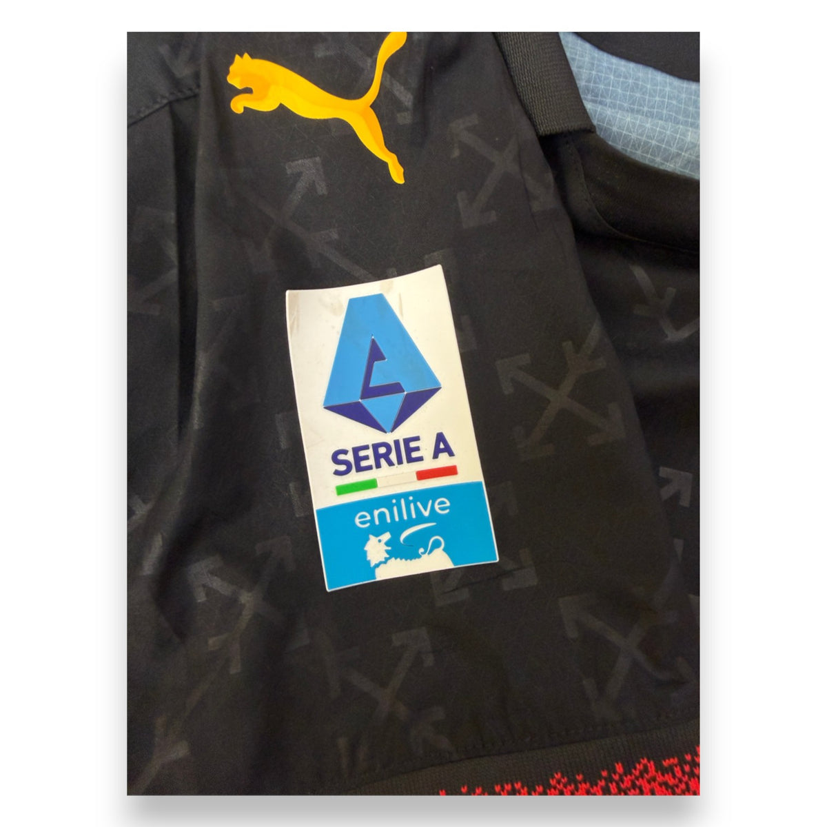 Dettaglio patch Serie A Enilive maglia Milan Off-White 2024-25 Maignan – logo Puma giallo