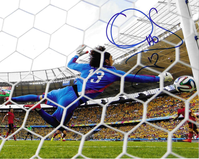 Fotografia autografata Guillermo Ochoa parata leggendaria Mondiali 2014 Messico vs Brasile maglia portiere blu numero 13 pallone Brazuca prospettiva interna porta – autografo originale pennarello blu con numero 13 in alto a destra – 25x20 cm – condizioni Excellent