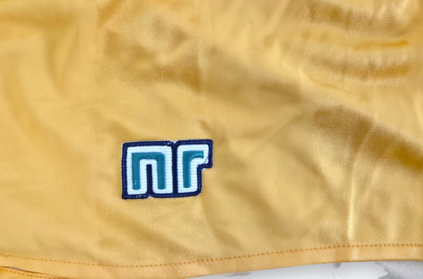 Dettaglio logo NR ricamato su pantaloncini vintage gialli – Made in Italy – cimelio autografato Campioni del Mondo 1982