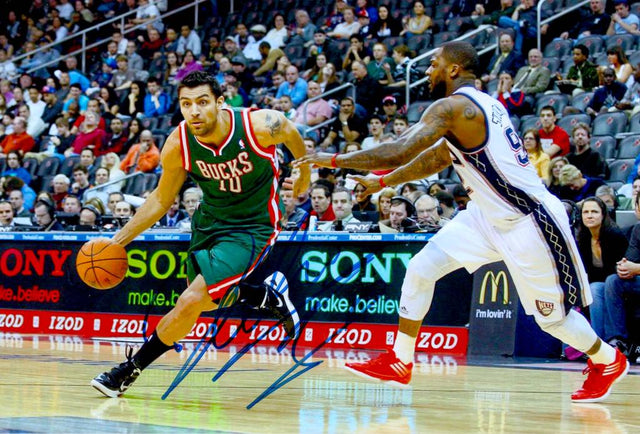 Fotografia autografata Carlos Delfino maglia Milwaukee Bucks NBA numero 10 – azione contro New Jersey Nets – autografo originale pennarello blu – 29x20 cm