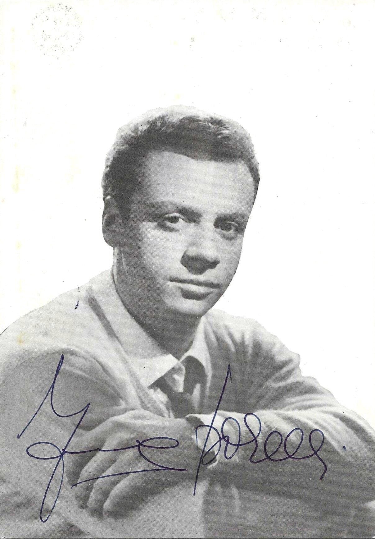 Fotografia autografata Johnny Dorelli ritratto bianco e nero press photo anni 60 giovane maglione chiaro cravatta sfondo chiaro – autografo originale inchiostro blu al centro – 15x10,5 cm – condizioni Excellent