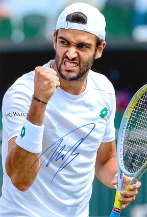 Fotografia autografata Matteo Berrettini tennista italiano esultanza pugno chiuso denti serrati Wimbledon Centre Court maglia Lotto bianca logo verde patch Capri Watch racchetta HEAD cappellino bianco al contrario – autografo originale pennarello blu – 29,8x20,2 cm