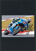 Fotografia autografata Maverick Vinales in curva sulla Suzuki Ecstar MotoGP numero 25 – montata su cartoncino nero – autografo originale pennarello nero – condizioni Excellent