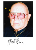 Fotografia autografata Rod Steiger ritratto a colori età avanzata occhiali fotocromatici rossi camicia blu collana oro sfondo nero striscia bianca in basso – firma originale pennarello nero Rod Steiger per esteso – 23,1x16,4 cm – condizioni Excellent
