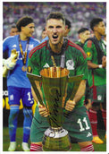 Fotografia autografata Santiago Giménez solleva trofeo CONCACAF Gold Cup urlo di gioia maglia Nazionale Messico verde Adidas numero 11 Ochoa sullo sfondo medaglia oro – autografo originale pennarello nero al centro – 30x21 cm – condizioni Excellent