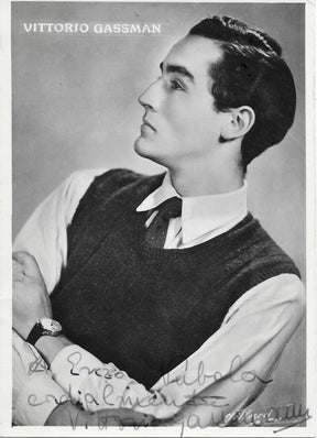 Cartolina ufficiale con dedica autografata Vittorio Gassman ritratto bianco e nero profilo alzato nobile gilet scuro camicia bianca orologio nome stampato in alto – dedica originale inchiostro grigio a Enzo Tubola cordialmente Vittorio Gassman – 15x10,5 cm – condizioni Excellent