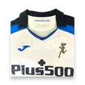Dettaglio collo maglia Atalanta Away 2021-22 Joma – stemma Atalanta Running oro e sponsor Plus500
