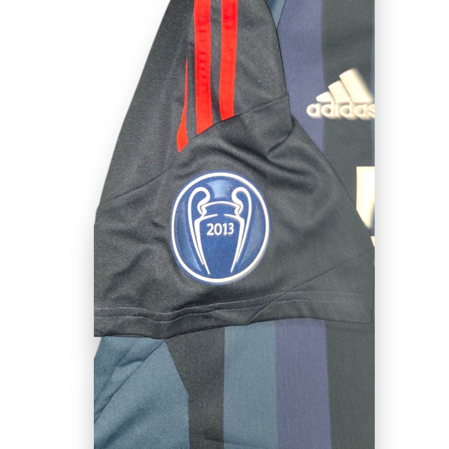 Dettaglio manica sinistra maglia Bayern Monaco Third 2013/14 patch ufficiale UEFA Champions League 2013 celebrativa vittoria Wembley finale contro Borussia Dortmund tre righine rosse Adidas