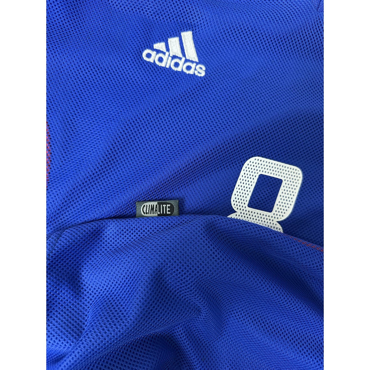 Dettaglio tessuto traforato Climalite e logo Adidas – maglia Francia Home 2002 Desailly