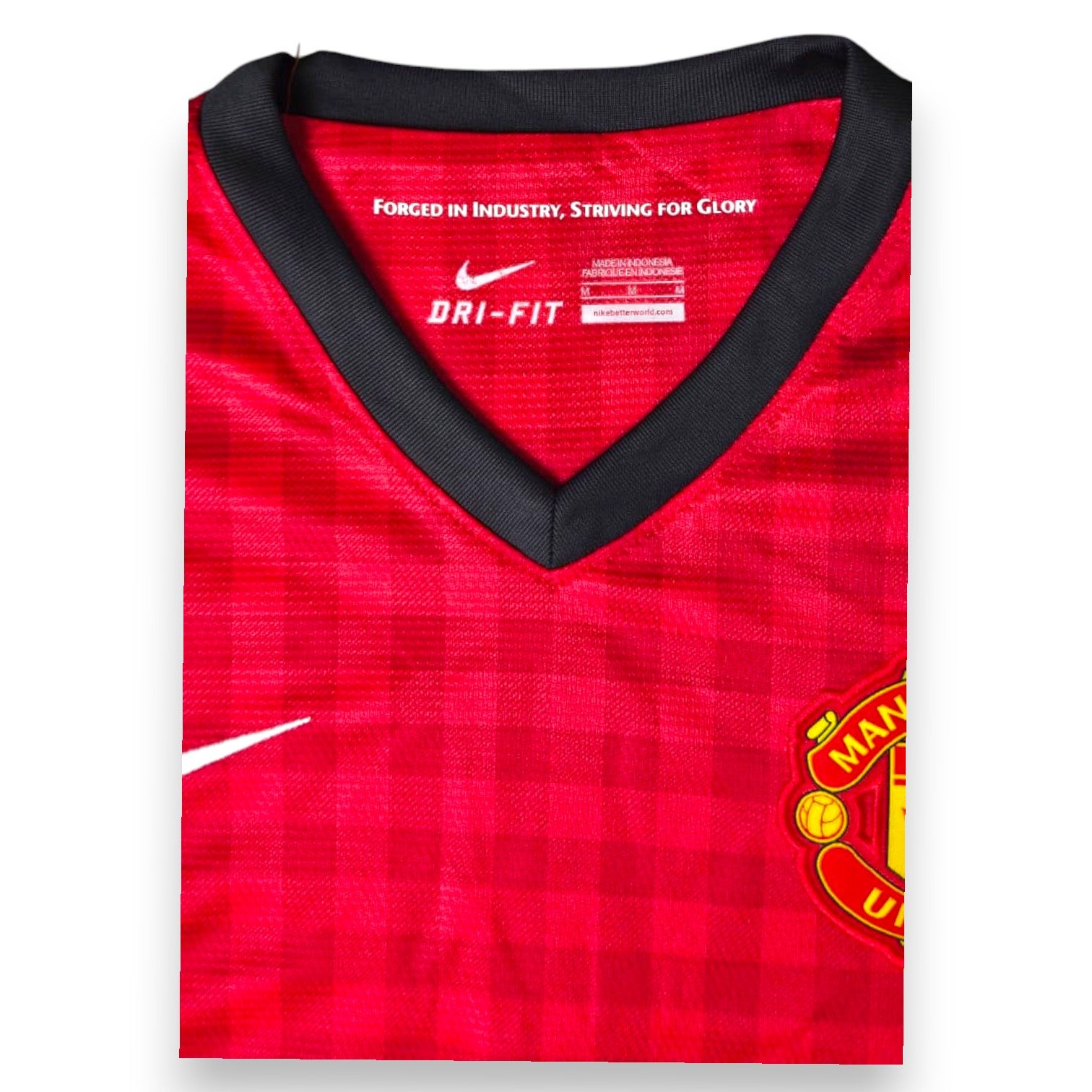 Dettaglio scollo a V nero Dri-FIT e stemma Manchester United maglia Home 2012-13 Nike – Forged in Industry Striving for Glory