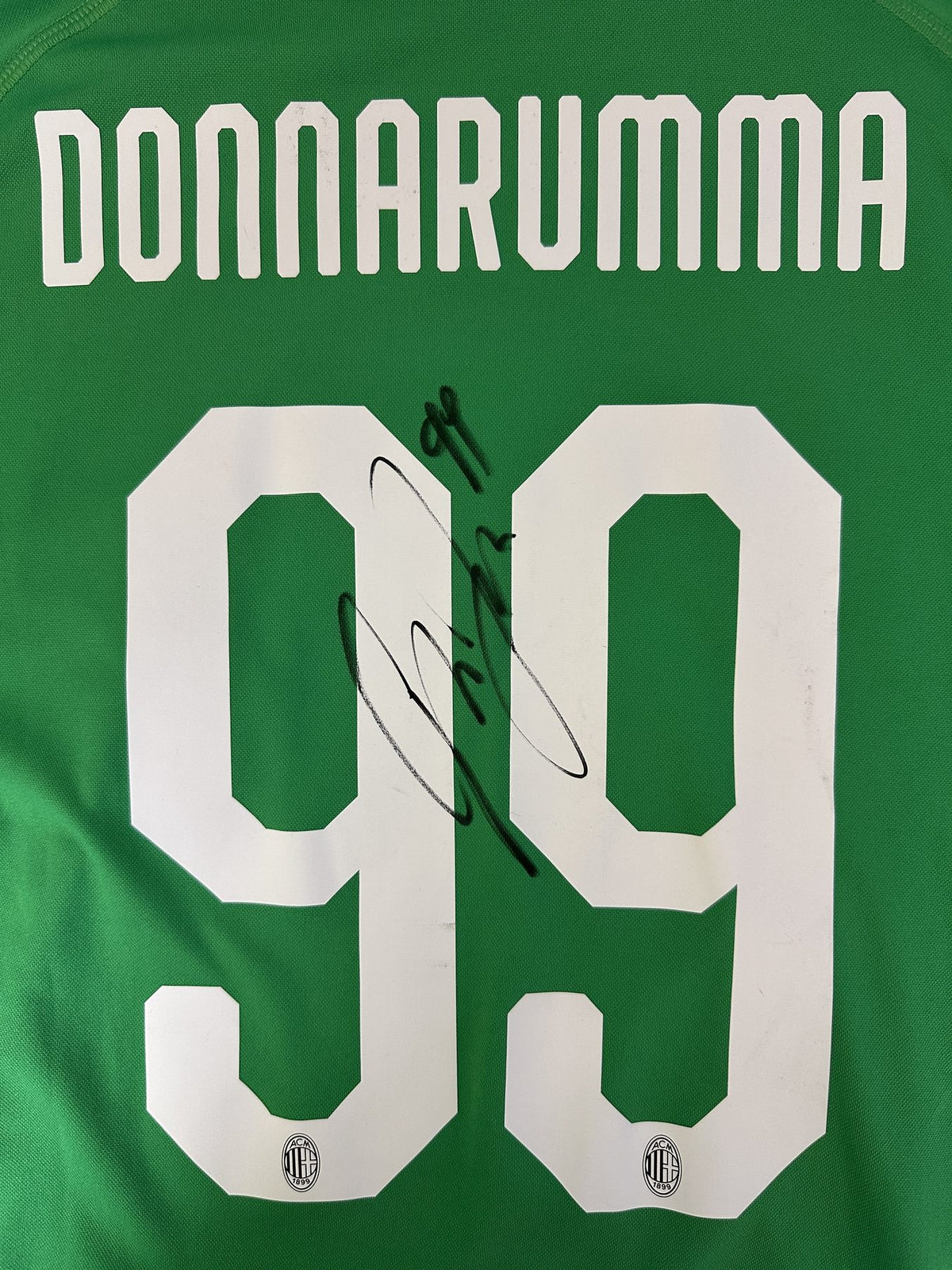 Dettaglio numero 99 e autografo originale Gianluigi Donnarumma su maglia Milan Portiere 2018-19