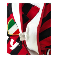 Cartellino Adidas con codice V13457 e data 10/11 accanto allo scudetto della maglia Milan 2011/12