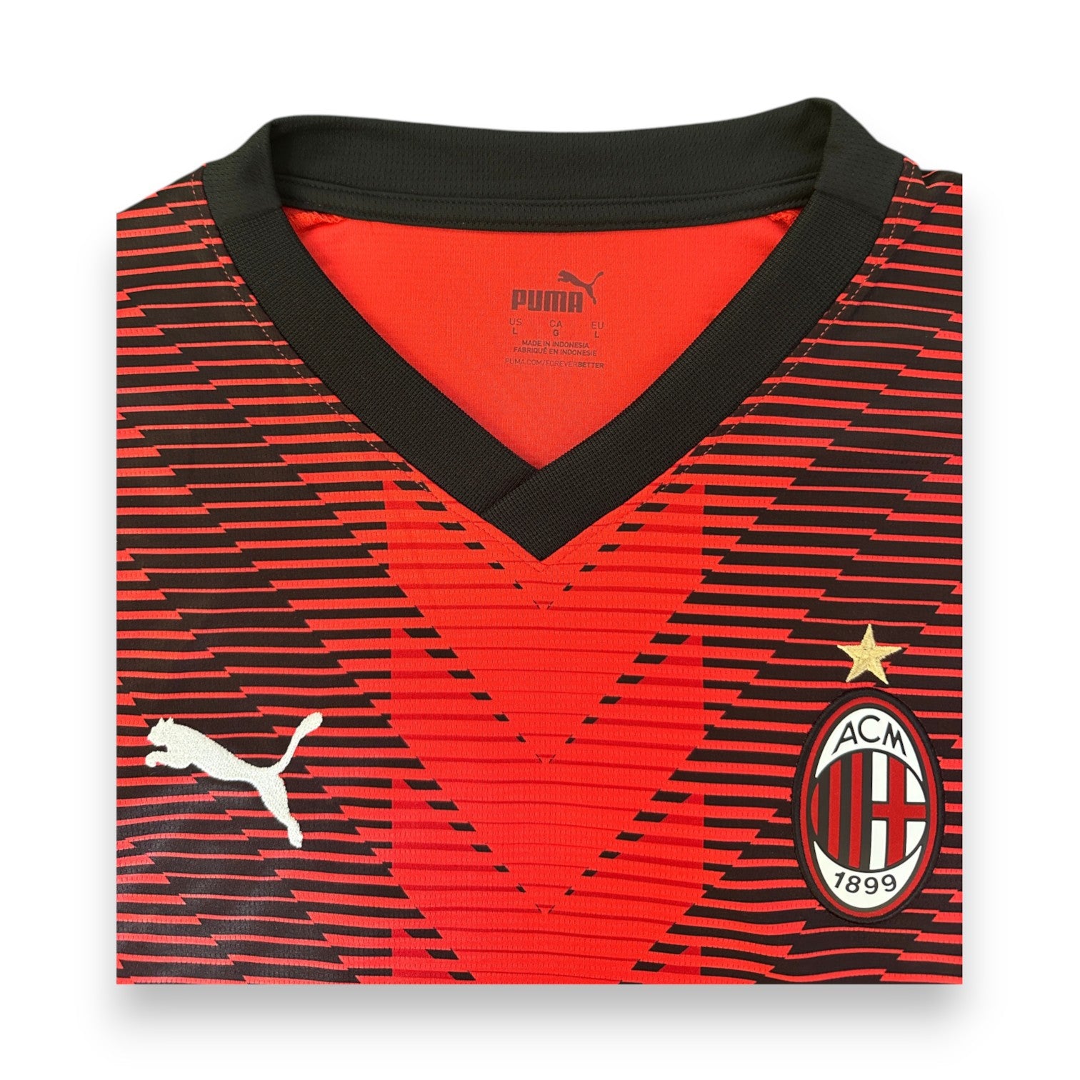 Dettaglio collo a V nero maglia Milan Home 2023-24 Puma – stemma ACM 1899 e stella oro
