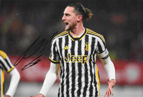 Fotografia autografata Adrien Rabiot esultanza maglia Juventus Home bianconera Adidas sponsor Jeep dettagli gialli due stelle fascia Peaceday stagione 2023-24 – autografo originale pennarello nero lato sinistro – 30x20,3 cm – condizioni Excellent