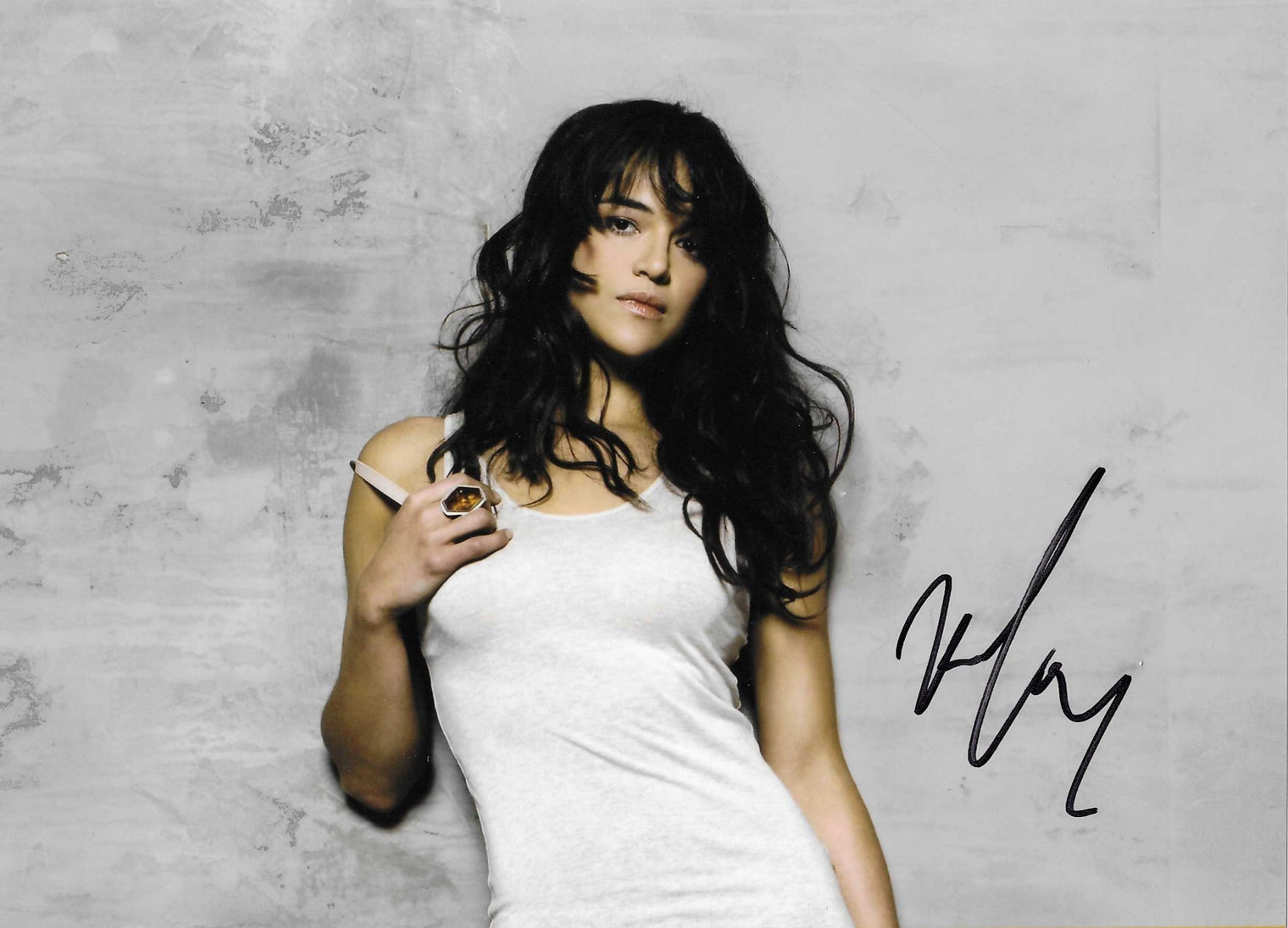 Fotografia autografata Michelle Rodriguez ritratto a colori posa distesa sfondo grigio – firma originale pennarello nero – 15,2x20,9 cm – condizioni Excellent