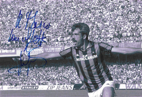 Fotografia autografata con dedica Pietro Paolo Virdis azione maglia Milan righe nere rosse Kappa sponsor Mediolanum stelle serie A anni 80 bianco e nero tribune stracolme – dedica autografo pennarello blu in alto a sinistra – 28,8x19,7 cm – condizioni Excellent